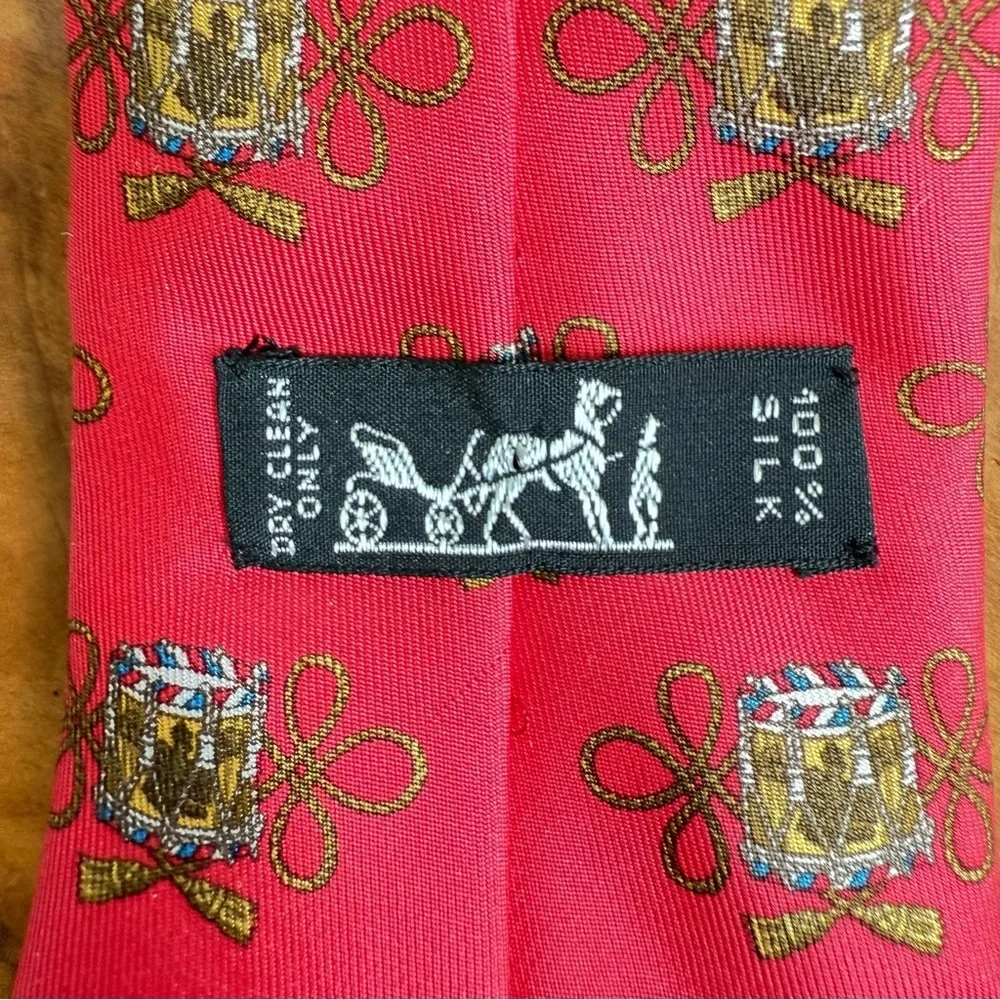 Vintage Hermès red silk tie with a repeating drum motif 3.5” x 54”
